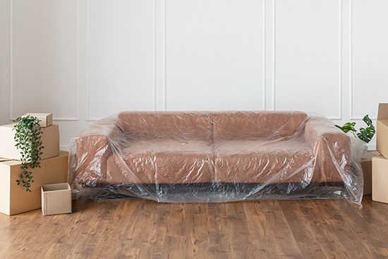 A lounge wrapped in plastic with moving boxes